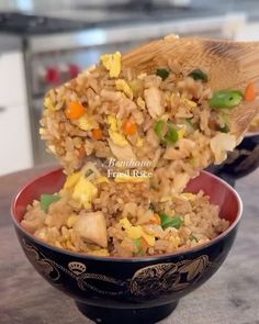 a bowl filled with rice and vegetables on top of a table