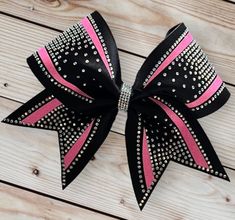 "Super cute Cheer Bow is made with 3\" Black Fabric Ribbon with Neon Pink Glitter & AB Rhinestone Bling Design and  Wrapped Center. Cheer Bow measures approximately 6\" wide and 6 1/2\" long. Cheer Bow is attached to a cotton seamless band. If you would like a different color or need to order more than one, please send me a message with your request. All bows are heat sealed to prevent fraying and come from a smoke free home." Pink And Black Cheer Uniform, All Star Cheer Bows, Cheer Bows Rhinestones, Cheer Bows Ideas, Sparkly Cheer Bows, Pink Cheer Bow, Cheer Swag, Bling Cheer Bows, Cheer Bow Ideas