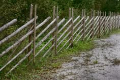 a long wooden fence next to a dirt road