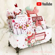 a christmas card holder with lots of cards in it on a white table next to a red and white ribbon