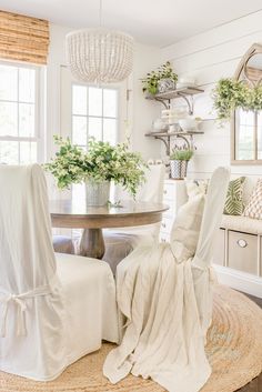 a dining room with white chairs and a round table