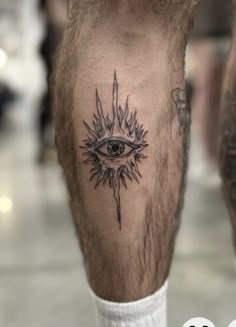 a man's leg with an all seeing eye tattoo on it