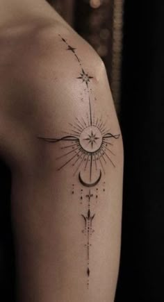 the back of a woman's shoulder with a sun and moon tattoo on it