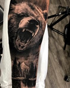 a man with a bear tattoo on his arm and leg, showing it's teeth