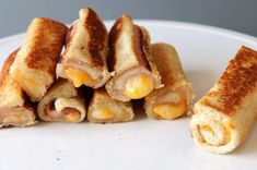 several sandwiches stacked on top of each other with cheese and meat in them, sitting on a white plate