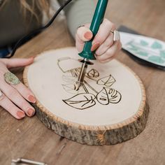 a woman using a wood carving tool on a piece of wood