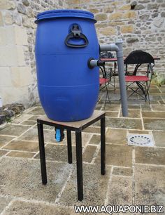 a large blue barrel sitting on top of a table next to a chair and table