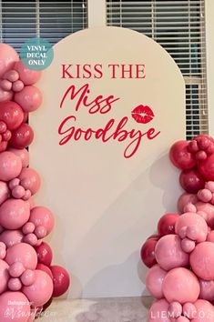 a sign that says kiss the miss goodbye and balloons are in front of it,