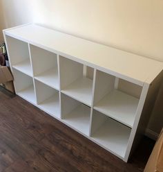 a white bookcase sitting on top of a hard wood floor