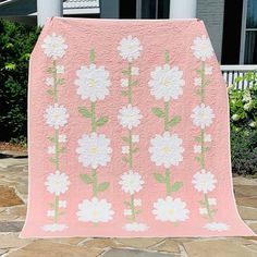 a pink quilt with white flowers on it