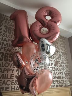 balloons and heliums are arranged in the shape of the number twenty eight on a wall