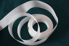 two rolls of white ribbon on a green background