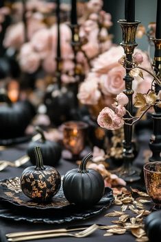 black and gold table setting with pumpkins, candlesticks and flowers on the table