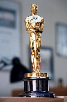 an oscar statue sitting on top of a wooden table