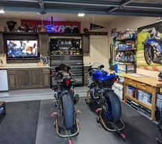 two motorcycles are parked in a garage with the tv on and shelves full of tools