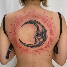 a woman with a tattoo on her back that has the moon and sun in it