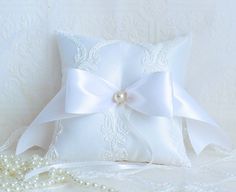 a white pillow with a bow and pearls