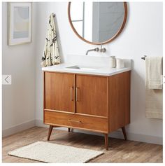 a bathroom with a sink, mirror and rug