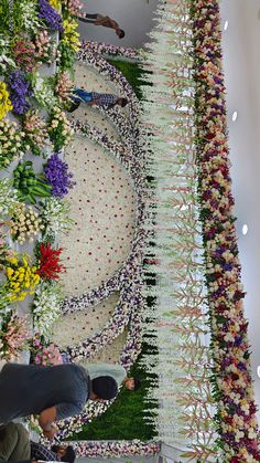 people are standing in front of a flower display