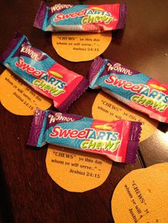 candy bar wrappers sitting on top of a wooden table next to envelopes with the words sweet tarts chew written on them