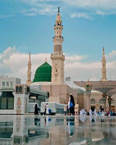 a group of people standing in front of a large white building with a green dome