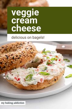 a bagel with cream cheese on it sitting on a plate next to another bagel