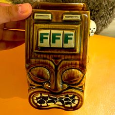 a person is holding up a ceramic figurine with the word fff on it