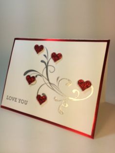 a card with hearts on it and the words love you written in red ink is displayed