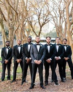 a group of men standing next to each other wearing tuxedos and bow ties