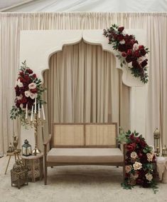 a couch sitting under a white tent with flowers on the wall and candles in front of it