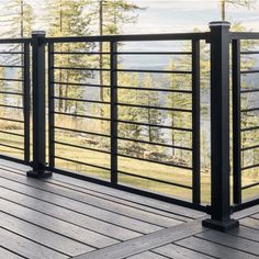 a wooden deck with metal railings and trees in the background