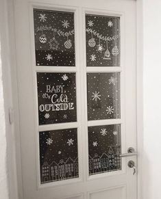 the door is decorated with black and white snowflakes, christmas decorations, and words