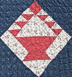 a close up of a quilted piece of cloth with red and white designs on it