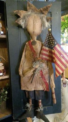 a wooden doll with an american flag hanging from it's back