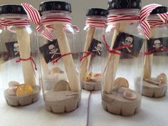 three glass jars with sand and wooden spoons in them