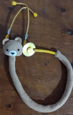 a stuffed animal with a stethoscope attached to it's head on a wooden table