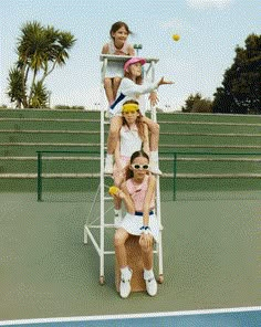 a group of people standing on top of a tennis court