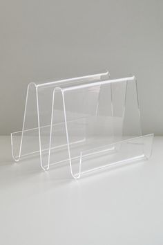 three clear acrylic stands on a white surface