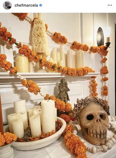 a table topped with candles and a skull head next to a bowl filled with flowers