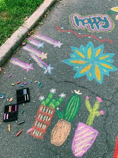 some crayons are laying on the ground next to chalk drawings and pencils