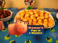 a table topped with lots of food next to a bowl filled with tater tots