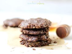 three chocolate cookies stacked on top of each other next to a jar of peanut butter