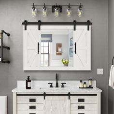 a bathroom with two sinks and a large mirror above the sink is decorated in gray tones