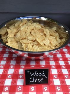 a bowl filled with food sitting on top of a red and white checkered table cloth