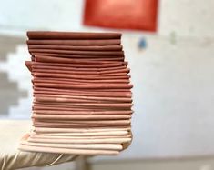 a stack of folded papers sitting on top of a white table next to a red chair