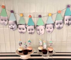 a table topped with cupcakes covered in frosting next to pictures of babies