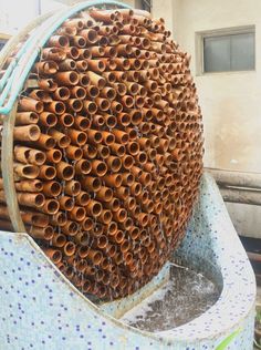 a large stack of brown pipes sitting on top of a blue and white tiled surface