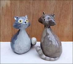 two ceramic cats sitting next to each other