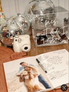 an open book on a table next to disco balls