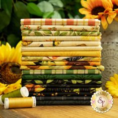 a stack of colorful fabrics with sunflowers in the background